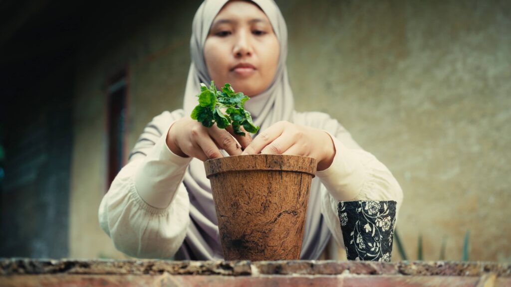 Azifah planting in a pot