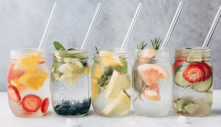 lima gelas infused water berisi berbagai buah-buahan